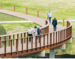 Several people walking on a curved bridge